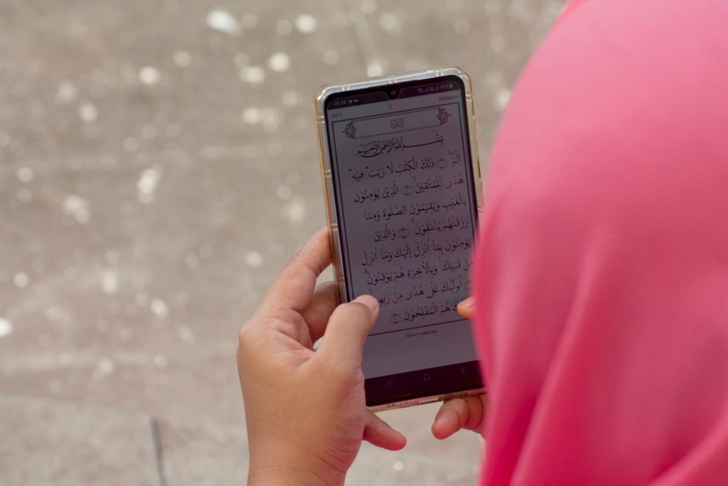Woman Reading Quran on Smartphone Apps